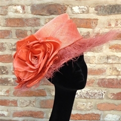 Unusual orange medium brim hat with feather brim and rose detail.
