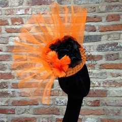 Bold orange fascinator with black rose and veiling detail.